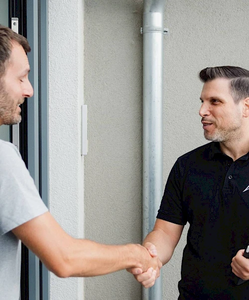 Ein Mann schüttelt einem anderen Mann die Hand.